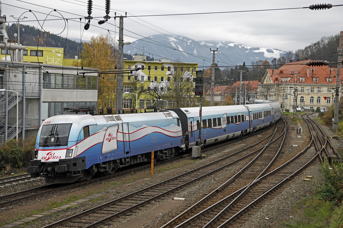 1116 251 (Ski-Austria) als RJ652 fhrt am 12.11.2013 in den Bahnhof Kapfenberg ein. Am rechten Bildrand ist noch ein letzter Rest des Dreischienengleises zum ehemaligen Landesbahnhofs zu erkennen. Das Normalspurgleis wird weiter als Anschlugleis zur Firma Bhler genutzt.