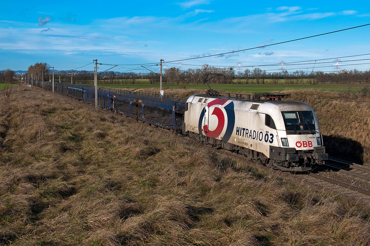 1116 264  Hitradio Ö3  fährt mit einem leeren Autozug kurz nach Himberg in Richtung Gramatneusiedl. Die Aufnahme entstand am 19.12.2014.