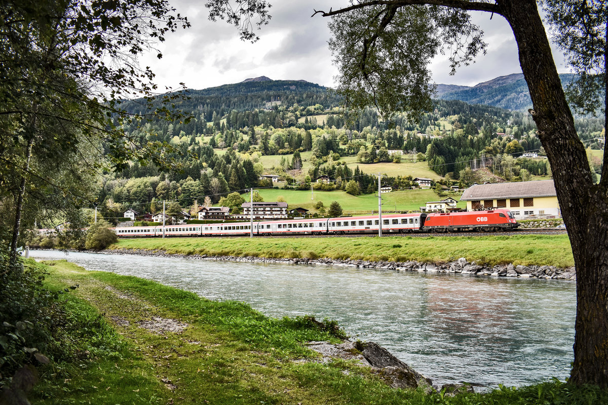 1116 275-9 durchfährt mit dem IC 632  Lienzer Dolomiten  (Lienz - Wien Hbf) die Haltestelle Berg im Drautal.
Aufgenommen am 6.10.2019.