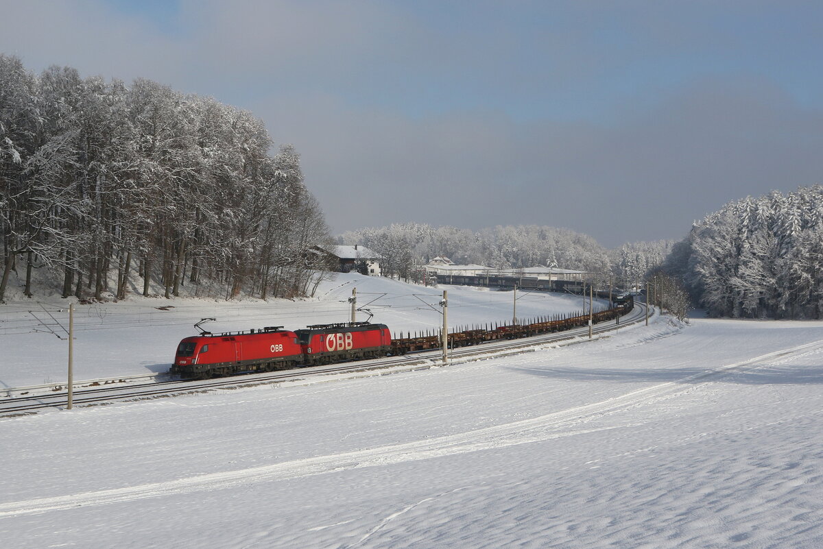 1116 278 und 1293 189 waren am 13. Januar 2024 mit einem gemischten Güterzug bei Axdorf im Chiemgau in Richtung Rosenheim unterwegs.