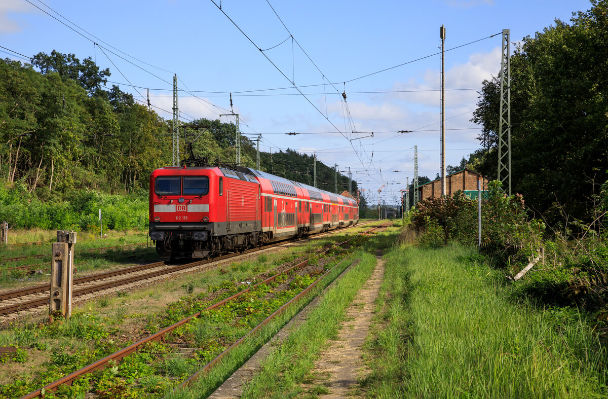 112 115 schub am 28.08.2022 den RE5 3515 von Stralsund Hbf nach Baruth (Mark). Aufgenommen bei der Ausfahrt in Demmin.