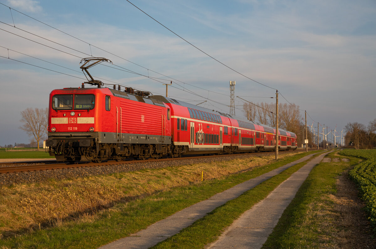 112 119 schiebt am 10.04.2023 den RE3 3317 nach Jüterbog. Aufgenommen in Groß Jasedow.