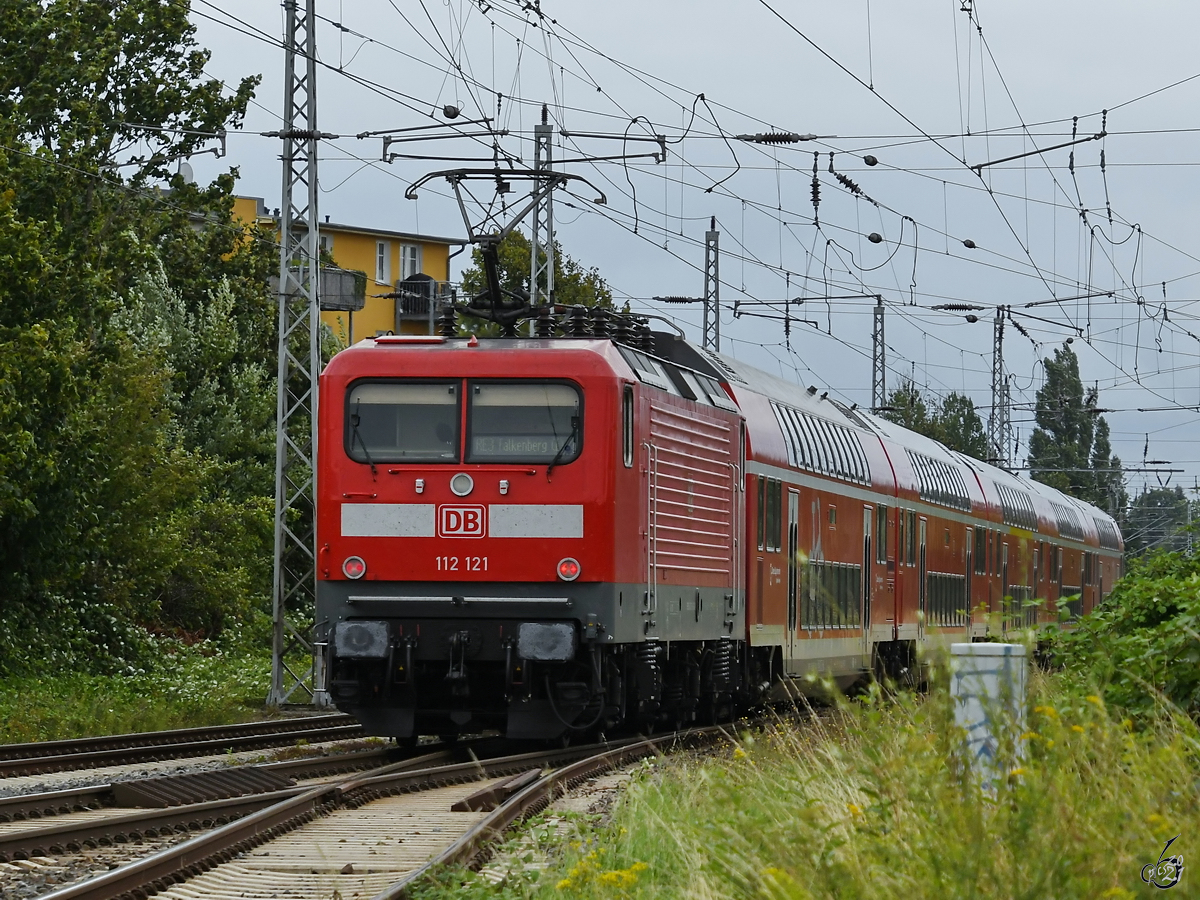 112 121 schiebt einen RE3 nach Falkenberg (Elster), so gesehen Mitte August 2021 in Greifswald.