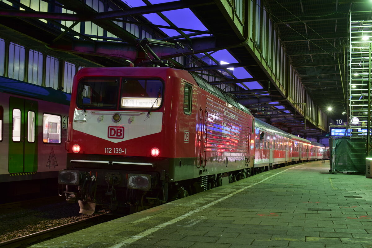 112 139-1 steht mit dem letzten Verstärkerzug des Tages nach Emmerich in Duisburg Hbf.

Duisburg 18.01.2022