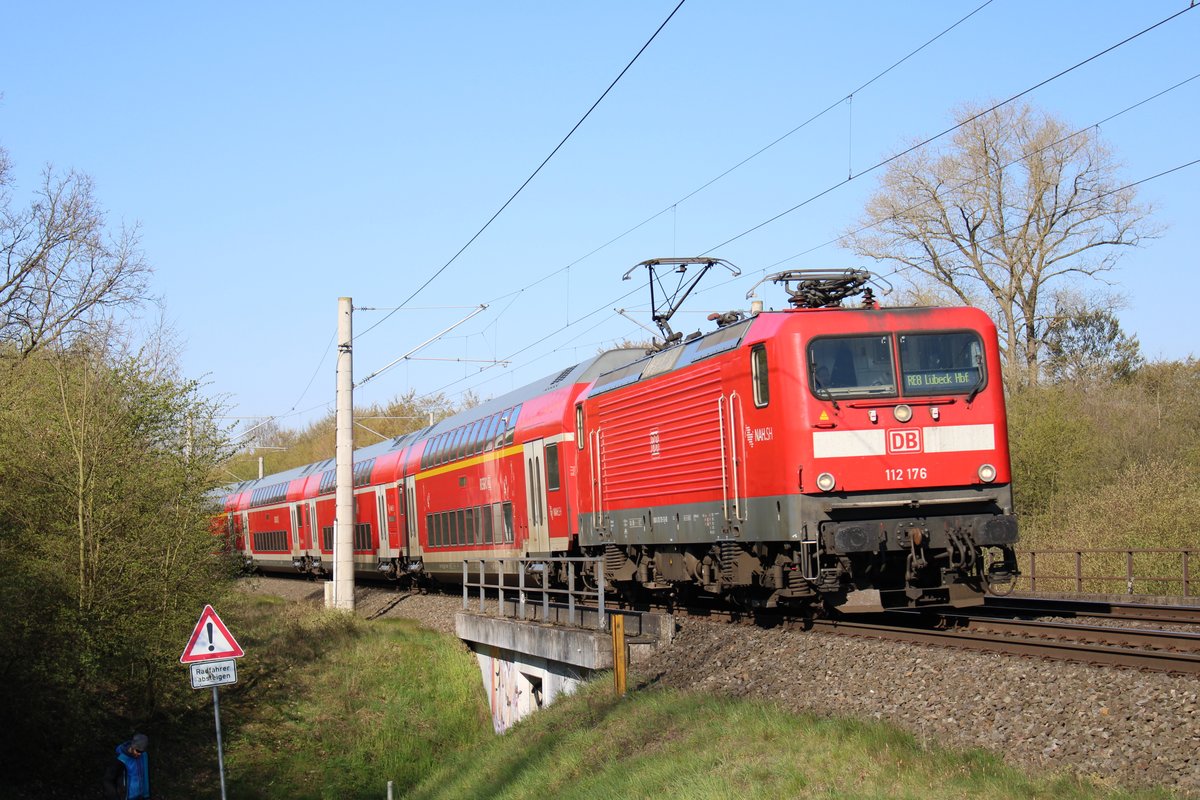 112 176 zieht den RE8 nach Lübeck Hbf. Das Bild entstand im April 2019, kurz hinter dem Halt Bad Oldesloe.