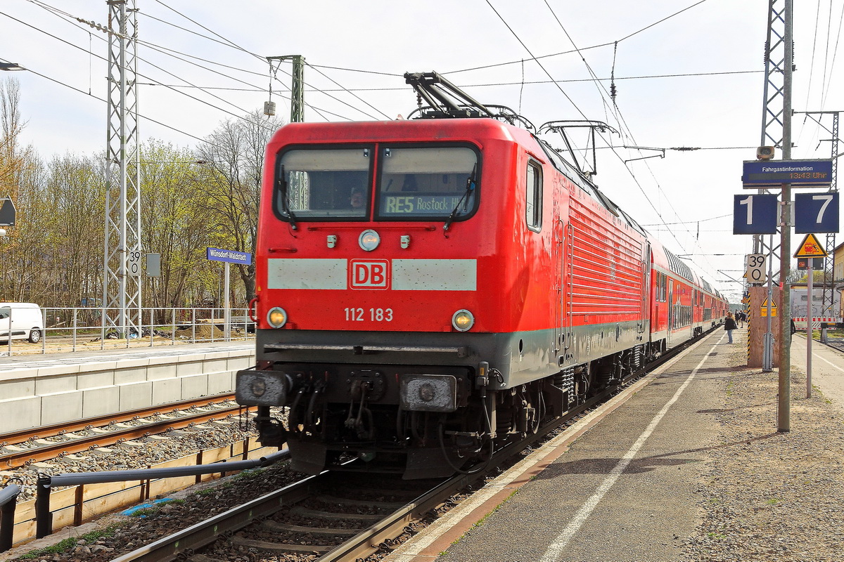 112 183 als RE 5 nach Rostock im Bahnhof Wünsdorf-Waldstadt auf Gleis 1 am 13. April 2022. 