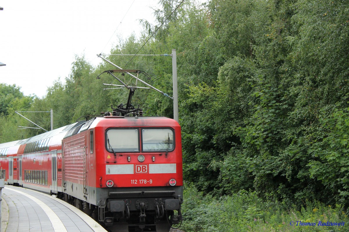 112.1 verläßt am 29.8.2015 den Bahnhof Lübeck-Travemünde Strand. Sie schiebt einen RE nach Hamburg Hbf über Lübeck Hbf.