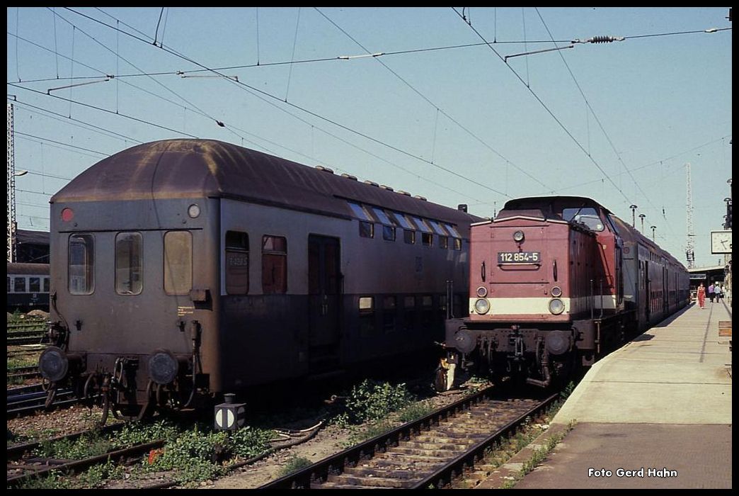 112854 wartet am 26.8.1990 im HBF Magdeburg vor einem Doppelstockzug nach Marienborn auf Abfahrt.