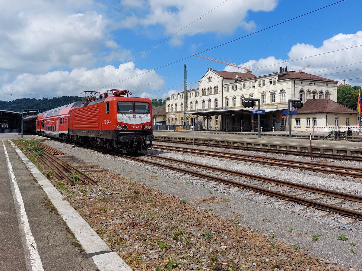 114 024 im Juni 2022 mit einem Ersatzzug vor dem imposanten Empfangsgebäude von Tübingen Hbf.