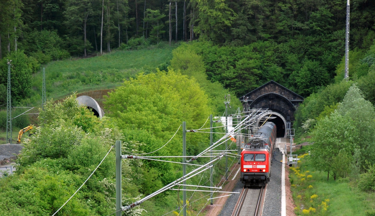 114 029 verlässt mit RE Fulda - Frankfurt den sanierten alten Schlüchterner Tunnel. Normalerweise ist dies das Süd-Nord-Gleis, aber am 9.5.2014 wurde wegen Rückbau der neuen Röhre auf eingleisigen Betrieb das Gleis durch den alten Tunnel für beide Richtungen benutzt.