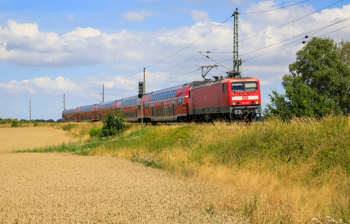 114 039 zog am 10.08.2022 den RE5 3513 von Stralsund nach Finsterwalde. Aufgenommen in Elmenhorst.