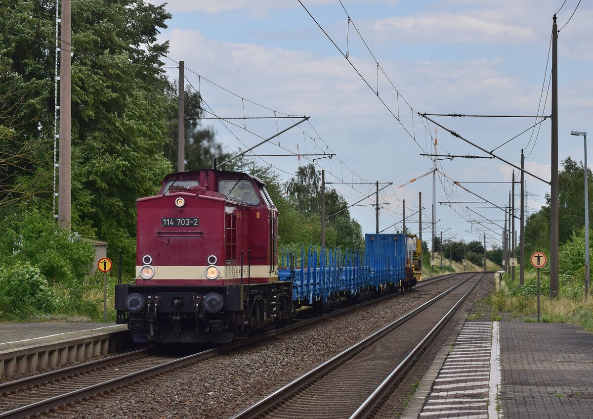114 703 fährt mit einem kurzem Bauzug mit einer Ramme beladen durch Ochtmersleben in Richtung Helmstedt.

Ochtmersleben 17.07.2023