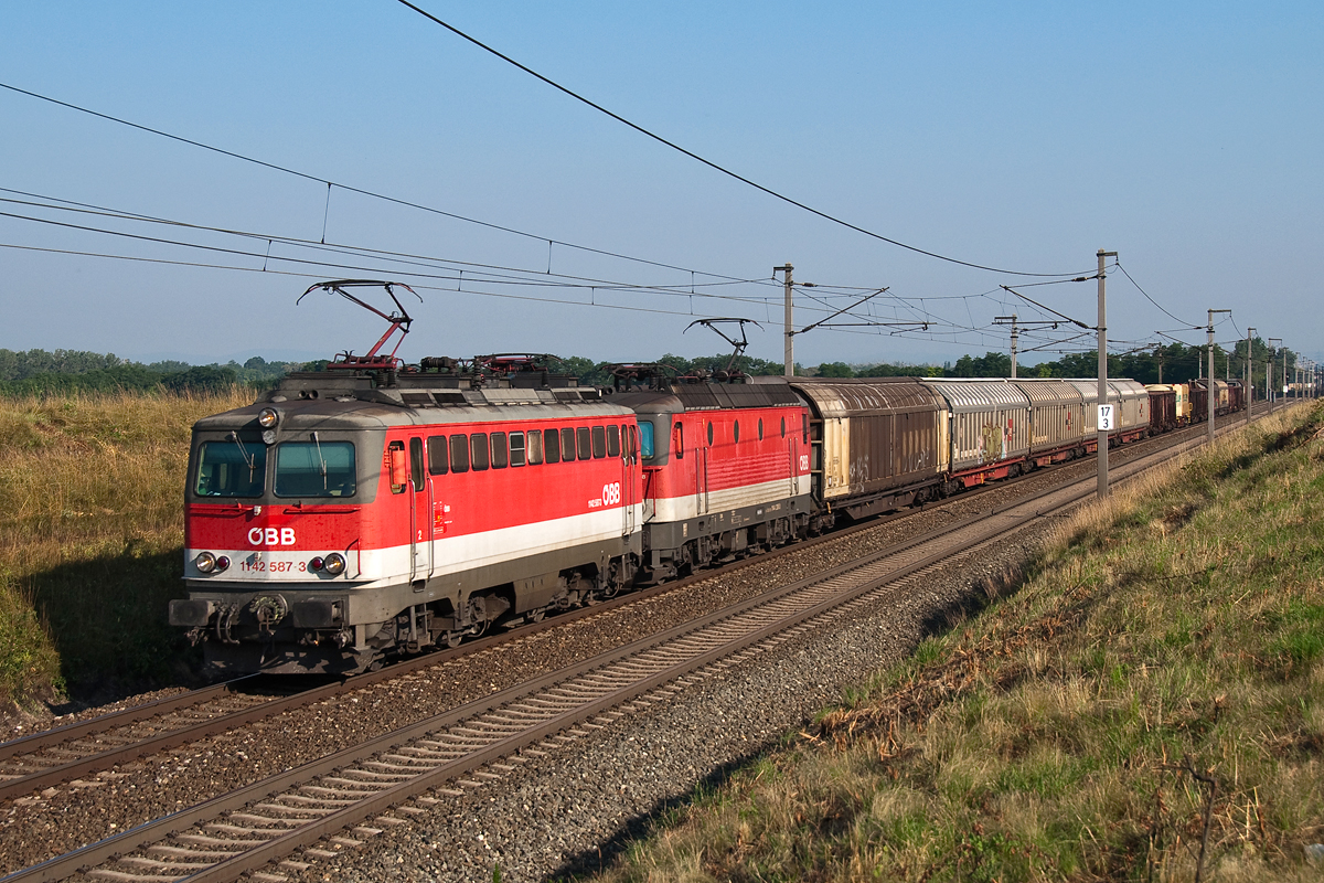 1142 587 und 1144 238, unterwegs mit einem Güterzug in Richtung Osten, am 19.07.2014 kurz vor Gramatneusiedl.