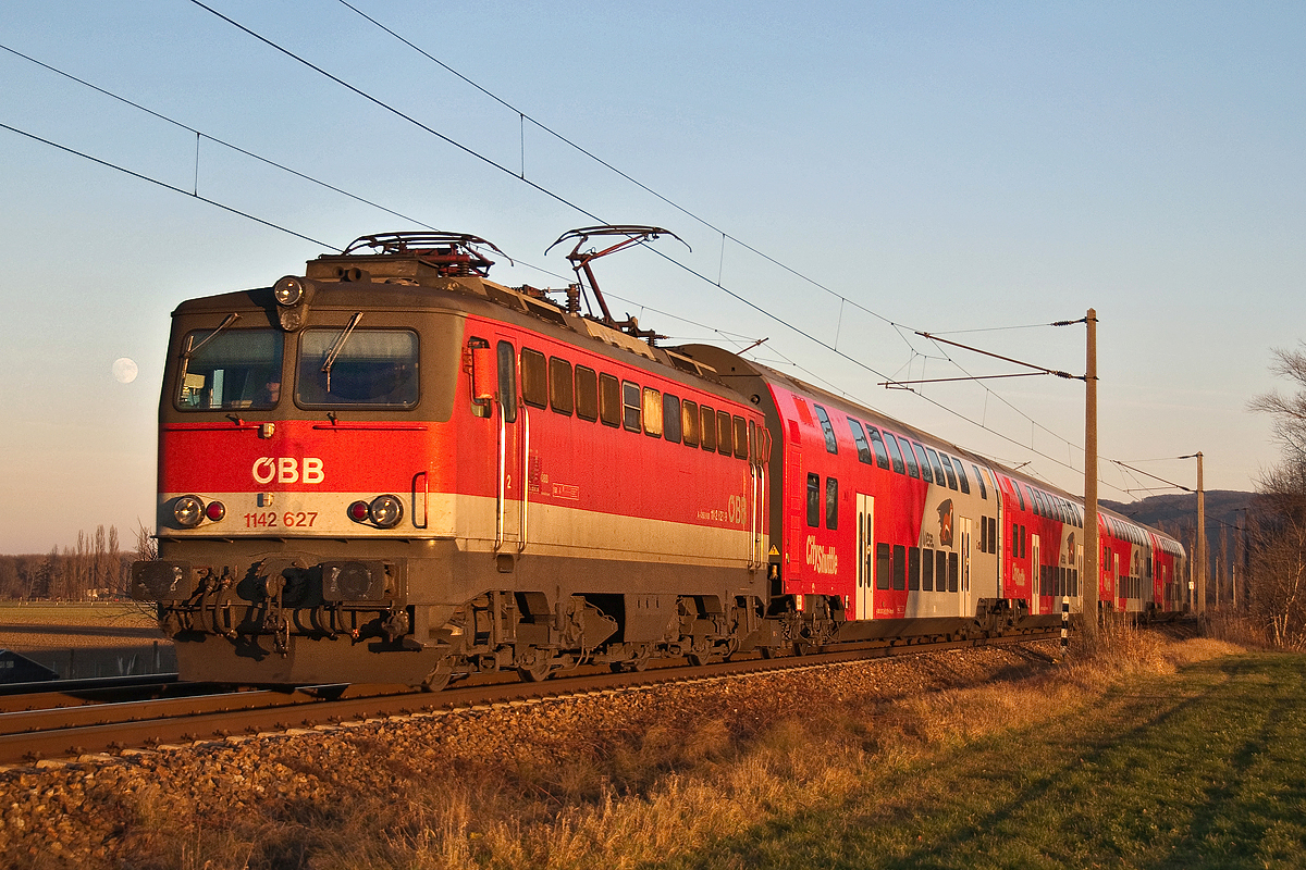 1142 627, mit dem REX 2828 am 23.12.2015 nachmittags, während die Sonne schon ziemlich tief stand, und der Mond aufgegangen war. Die Aufnahme entstand kurz vor Muckendorf-Wipfing.