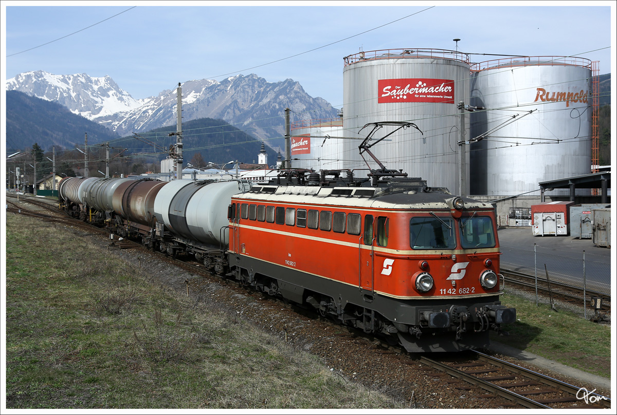 1142 682 rollt mit dem Ölzug 76674 in Richtung Donawitz. Im Hintergund sieht man die Ausläufer vom Hochschwab Gebirge und vorne die Firma Rumpold. 
Trofaiach 21.3.2014