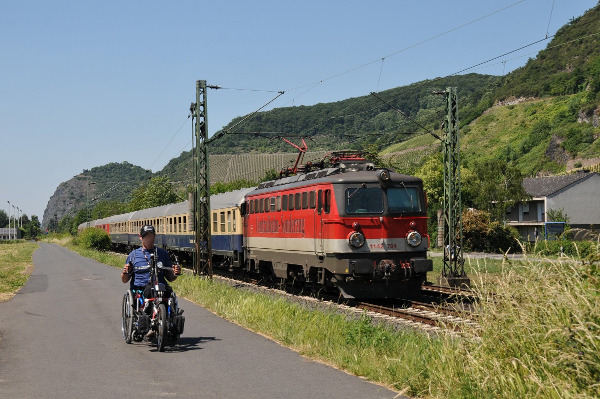 1142 704 der Centralbahn mit einem Sonderzug am Haken rollt rheinabwärts gen Koblenz. Der Handbikefahrer freute sich an diesem heißen Tag sicher über den vom vorbeirauschenden Zug verursachten Fahrtwind. Die Aufnahme entstand am 05/06/2015 in Leutesdorf.