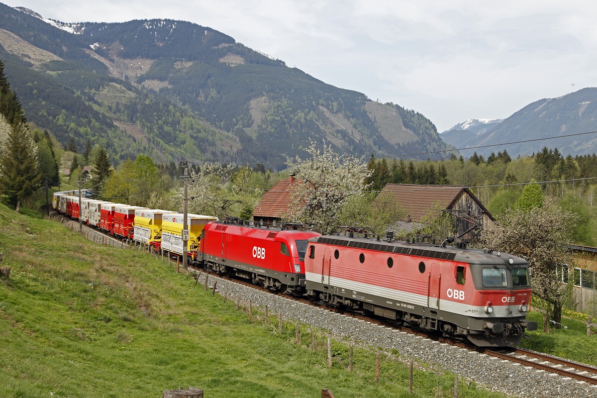 1144 020 + 1016 065 ziehen am 5.05.2015 einen Erzleerwagenzug bei Admont durch das Ennstal.