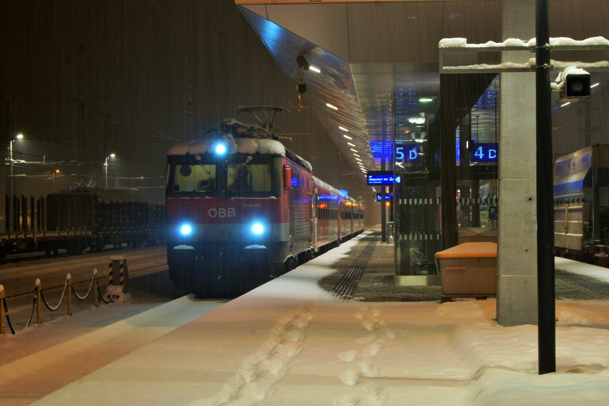 1144 021 der ÖBB hat am frühen Morgen des 12.02.2018 im Bahnhof Spittal-Millstättersee den Halt des EN aus Zürich abgewartet und macht sich in Kürze mit Zug 4216 der S1 auf den Weg nach Klagenfurt.