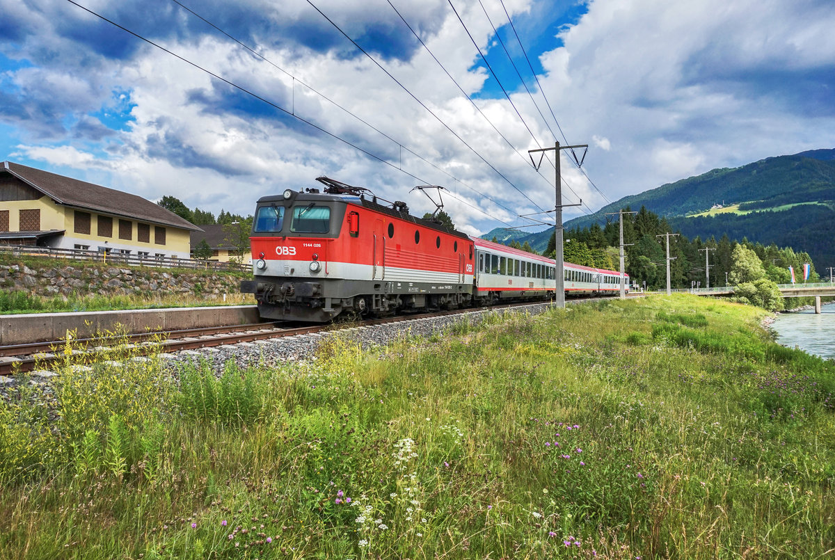 1144 026-2 durch fährt mit dem D 735 (Villach Hbf - Lienz) die Haltestelle Berg im Drautal.
Aufgenommen am 29.6.2017.