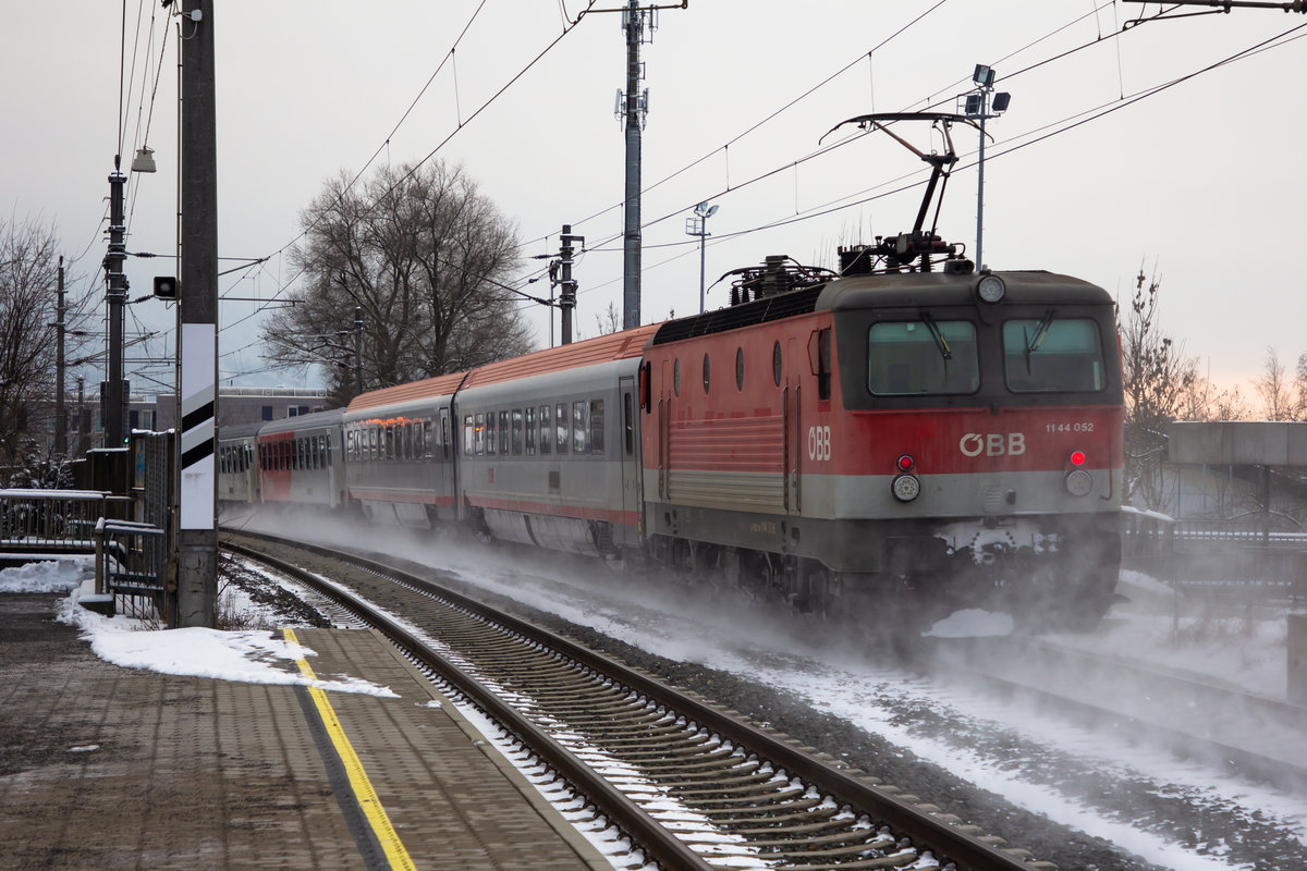 1144 052-4 schiebt ihren Fernverkehrsregionalzug durch Dornbirn Haselstauden. 11-2.21