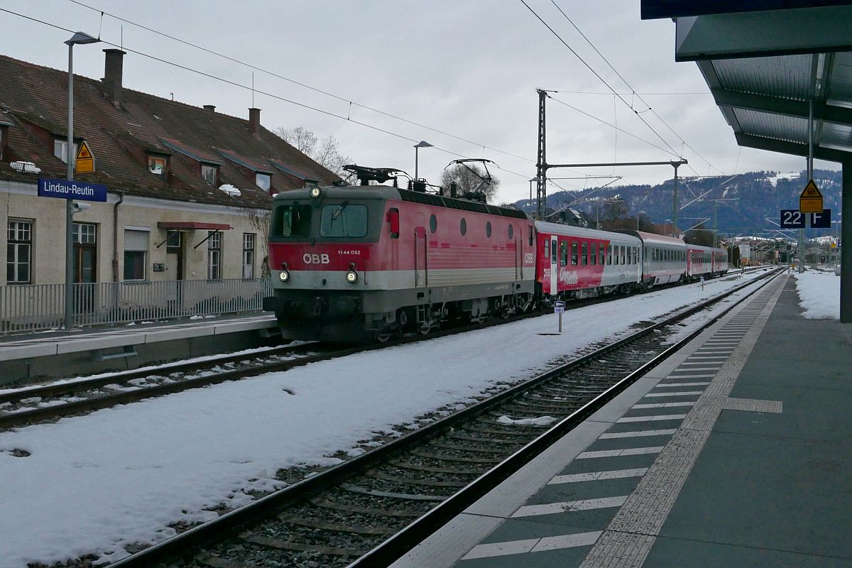 1144 052 fhrt mit den Wagen des REX 5578, Bludenz - Lindau-Insel, am 25.01.2021 auf Gleis 21 in den neuen Bahnhof Lindau-Reutin und passiert das ehemalige und nicht mehr in Betrieb befindliche Bahnhofsgebude.