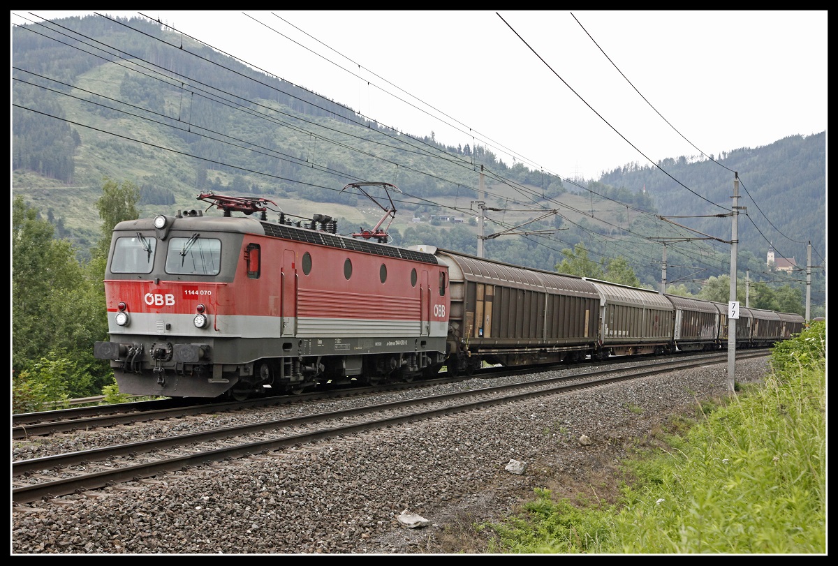 1144 070 mit Güterzug zwischen Bruck an der Mur und Niklasdorf am 2.07.2019.