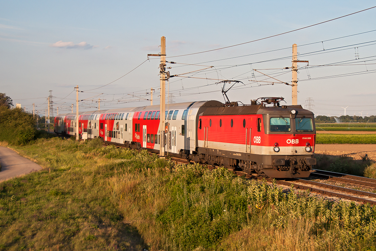1144 089 mit dem R 2363 nach Wiener Neustadt, im Abendlicht des 17.07.2017 bei Deutsch Wagram.