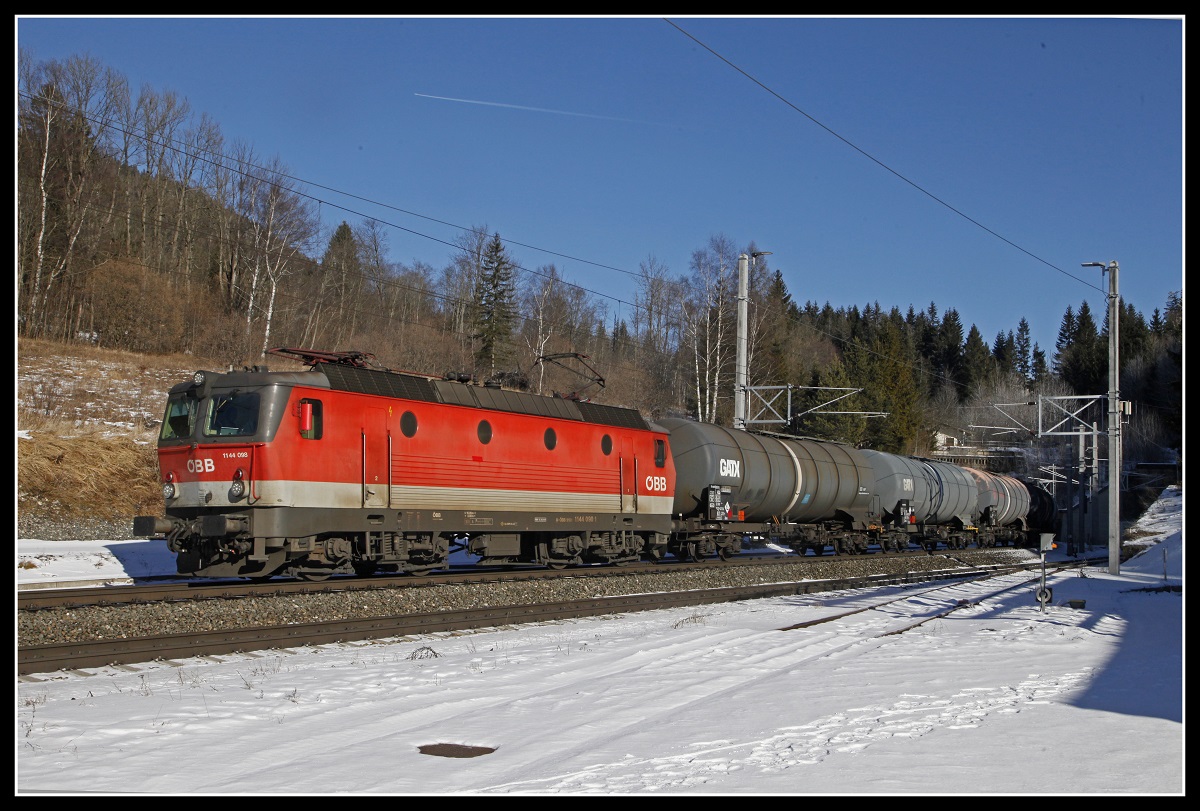 1144 098 mit Güterzug zwischen Semmering und Steinhaus am 21.01.2020.