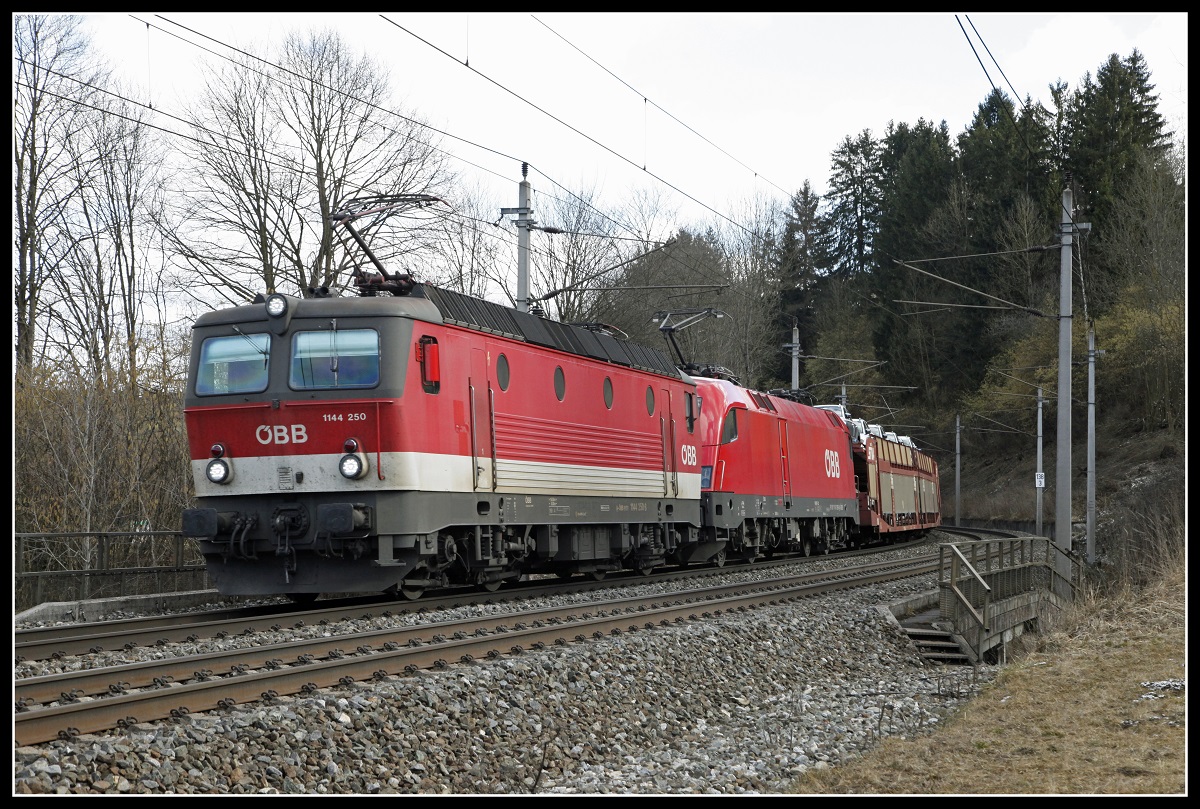 1144 250 + 1116 129 fahren am 27.02.2020 mit einem Güterzug bei Kindberg durchs Mürztal.