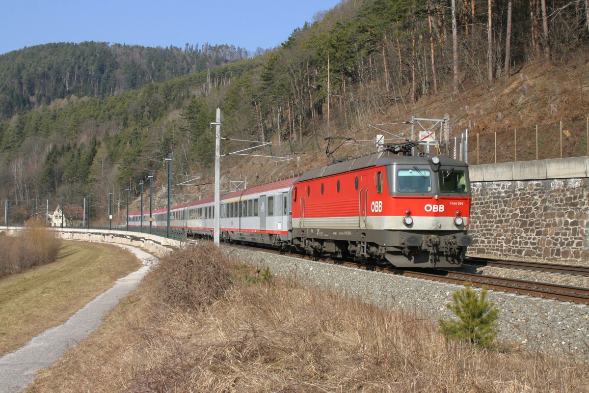 1144.091 fährt mit EC-158 die Steinmauer kurz vor Gloggnitz entlang. 21.2.15