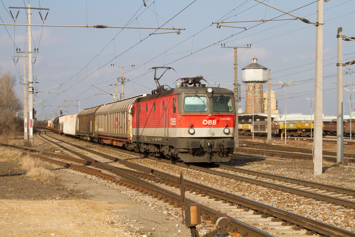 11444 063 mit einem langen Güterzug in Süssenbrunn. (27.02.2015)