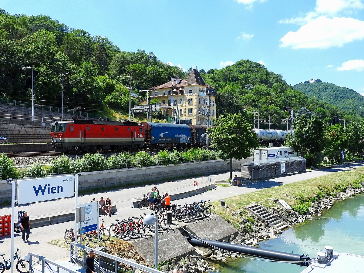 1144xxx-x passiert entlang der Franz-Josefs-Bahn in Richtung Wien-Nußdorf mit einem Güterzug die Schiffsanlegestelle Wien Nr.34; 230629