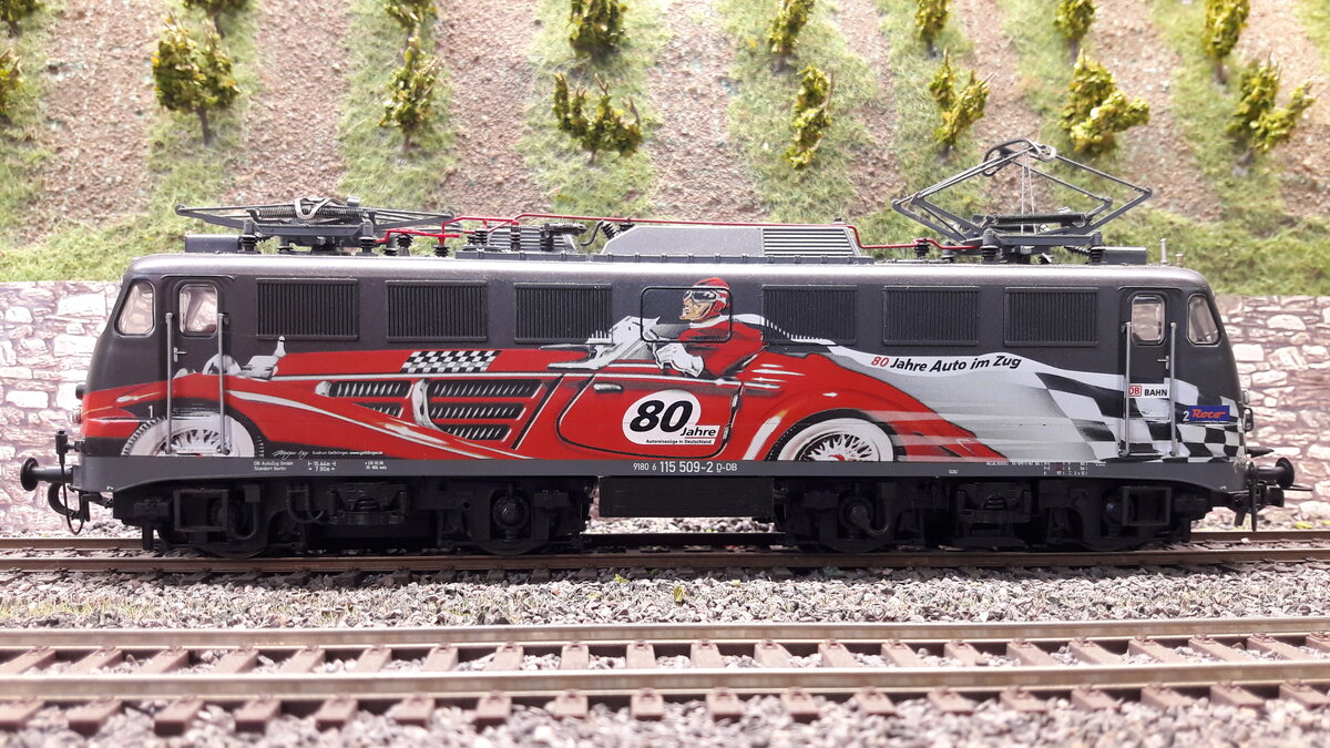 115 509-2 in Sonderlackierung   80Jahre Auto am Zug , vor den Weinbergen in Harrstadt.
Modell Roco 62547
