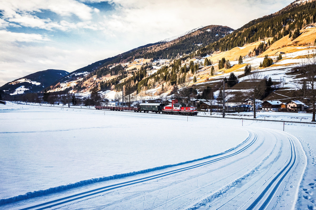 1163 014-4  Günter  fährt mit einem VG von Awanst Holzhof Arnbach nach Lienz bei Sillian vorüber.
Aufgenommen am 22.12.2017.