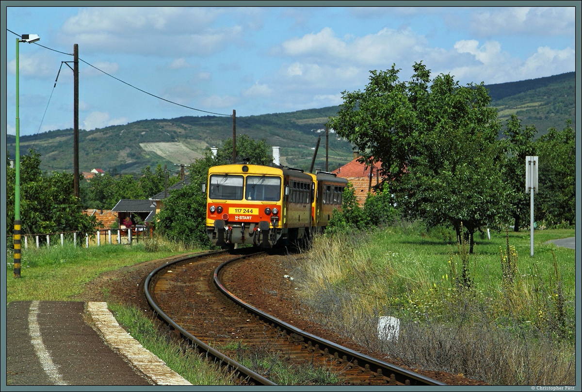 117 244 ist am 18.08.2014 auf der Strecke Szerencs - Hidasnémeti im Einsatz, hier auf der Fahrt durch Rátka.