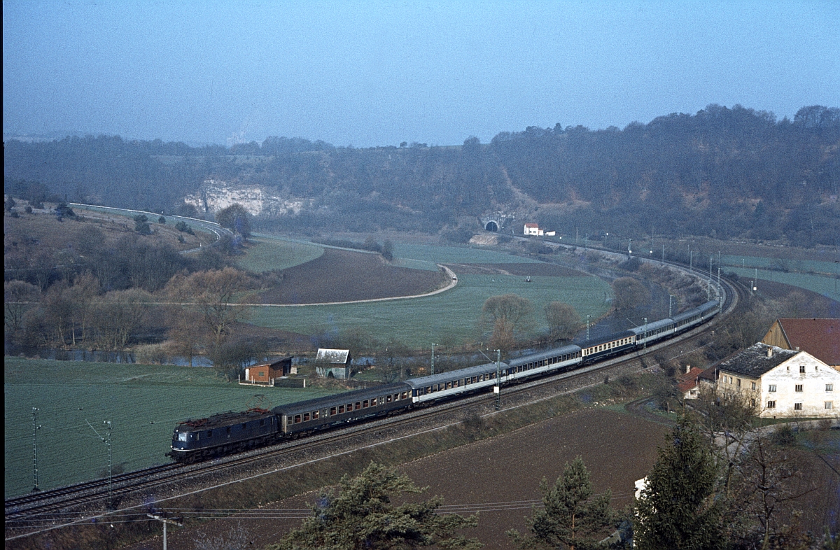 118 002 mit D 1285 Coburg - Mnchen im Mai 1980 im Altmhltal bei Dollnstein. Man beachte die Schnellzugwagen in  Pop -Lackierung, die damals schon selten waren.