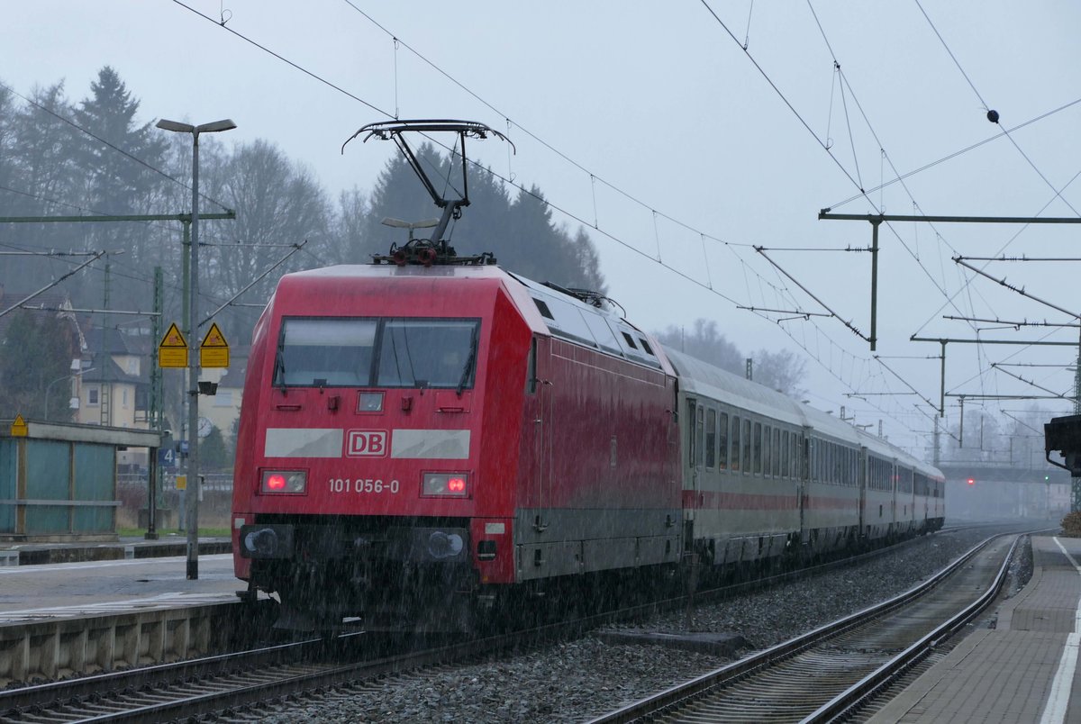 12. Dezember 2017, Mit dem wegen der Verlegung des ICE-Verkehrs vom Frankenwald auf die Neubaustrecke viel gescholtenen neuen Fahrplans hat Kronach zur Mittagszeit wieder einen IC-Halt bekommen. IC 2063 von München ist pünktlich eingefahren. 18:26 Uhr soll die Gegenleistung von Berlin hier eintreffen. Lok 101 056 scheint das Sauwetter nichts auszumachen.