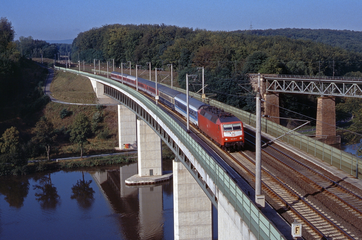 120 125 mit IC nordwärts auf der Fuldabrücke bei Kragenhof am 28.7.1991. Im Hintergrund die Brücke der Strecke nach Eichenberg.