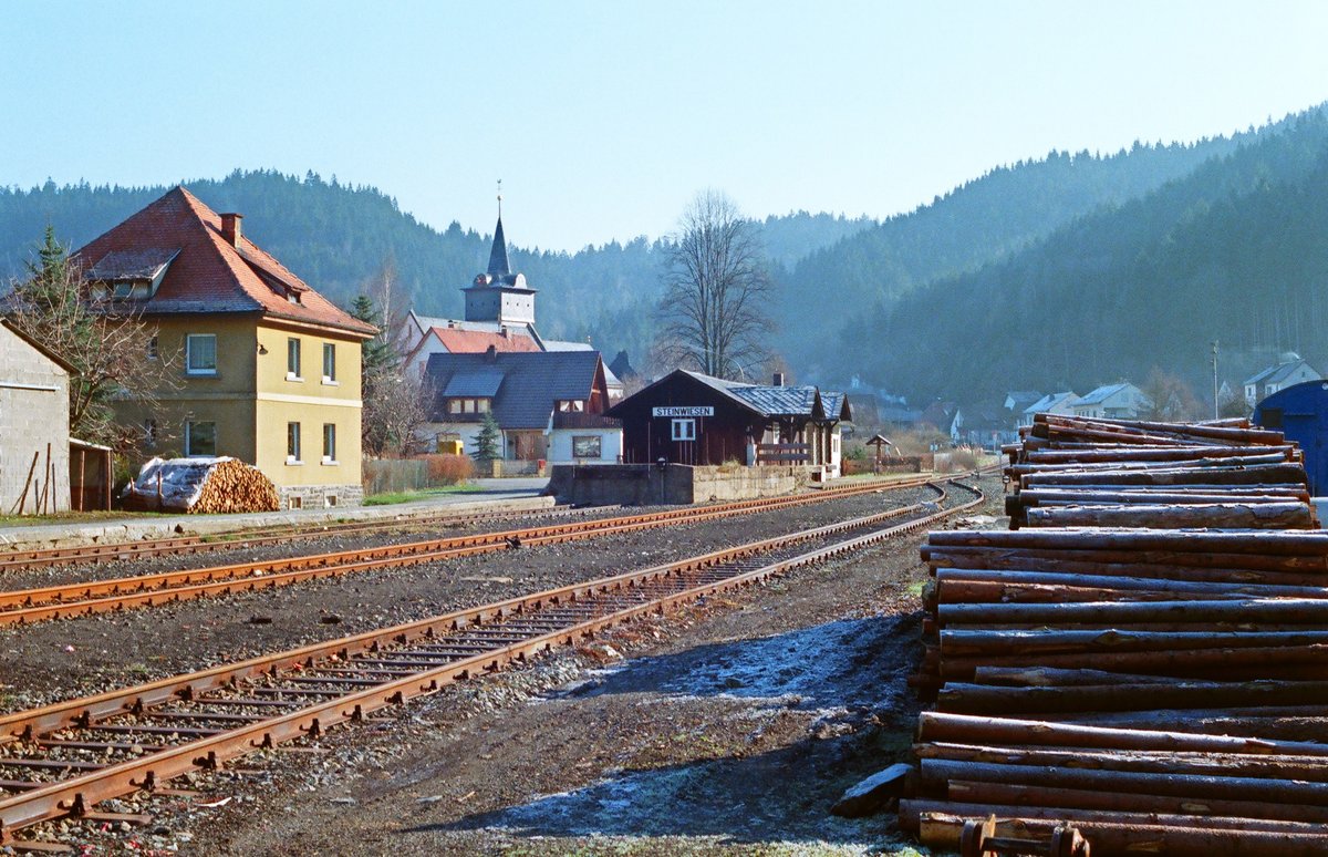 12.04.1987 Rodachtalbahn Kronach - Nordhalben, ein kalter Morgen am Bahnhof Steinwiesen. Zum Zeitpunkt der Aufnahme kam ab und zu noch eine Holzfuhre nach Kronach vorüber. Heute endet hier die von einem Verein betriebene Strecke von Nordhalben. Die links nach Kronach führenden Gleise sind entfernt.