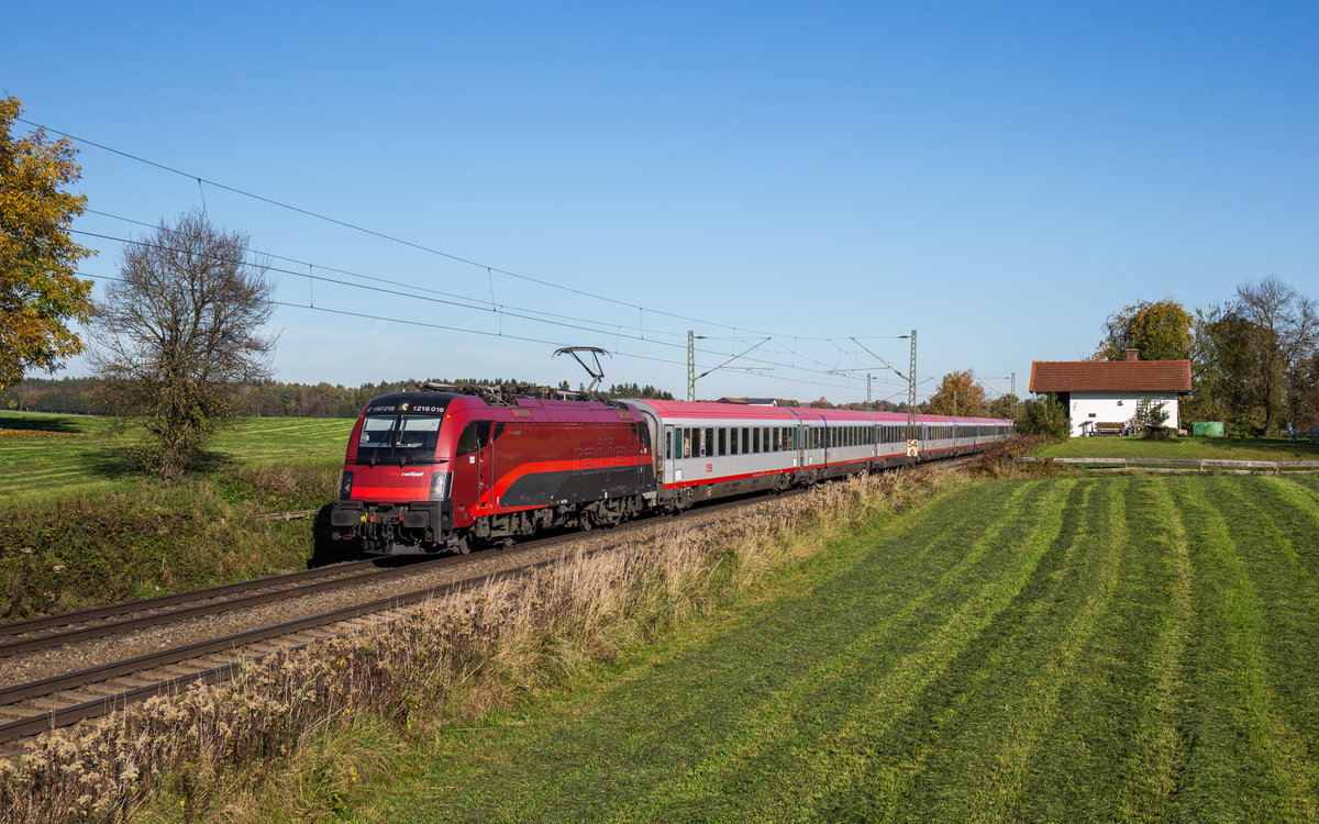 1216 018, die bereits im RJ-Design unterwegs ist, fährt mit einem Eurocity bei Hilperting in Richtung Brenner, aufgenommen am 19. Oktober 2017.