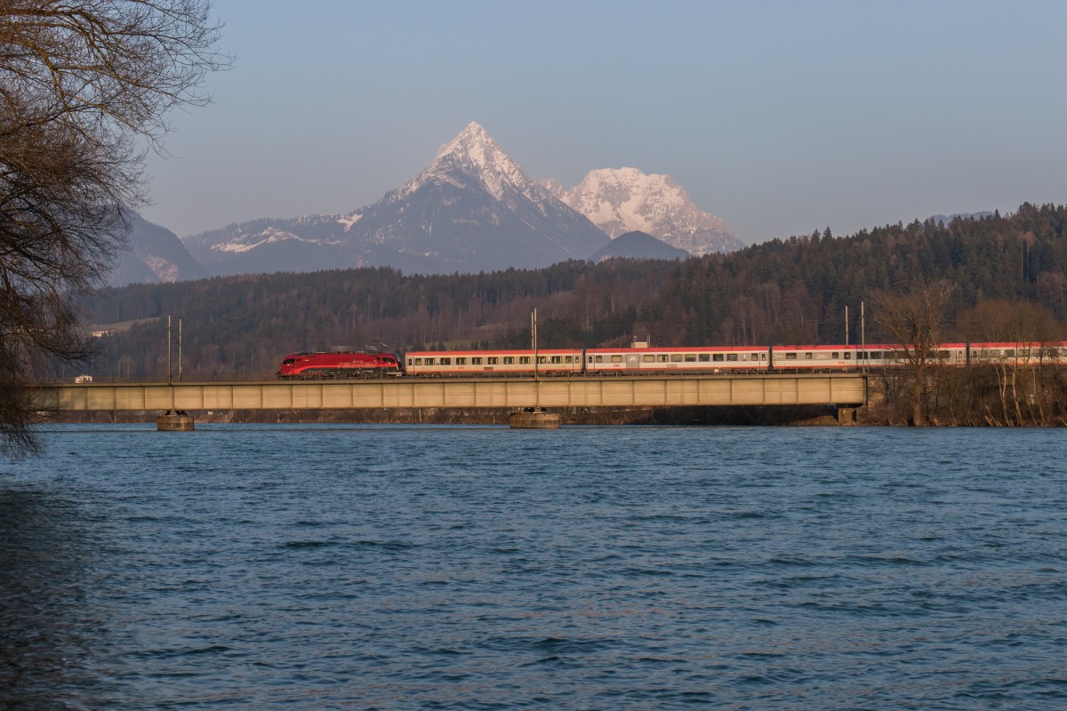 1216 018, schon mit Railjet-Lack versehen, fährt im letzten Licht des Tages mit einem EC über den Inn bei Langkampfen, aufgenommen am 19. März 2016.
