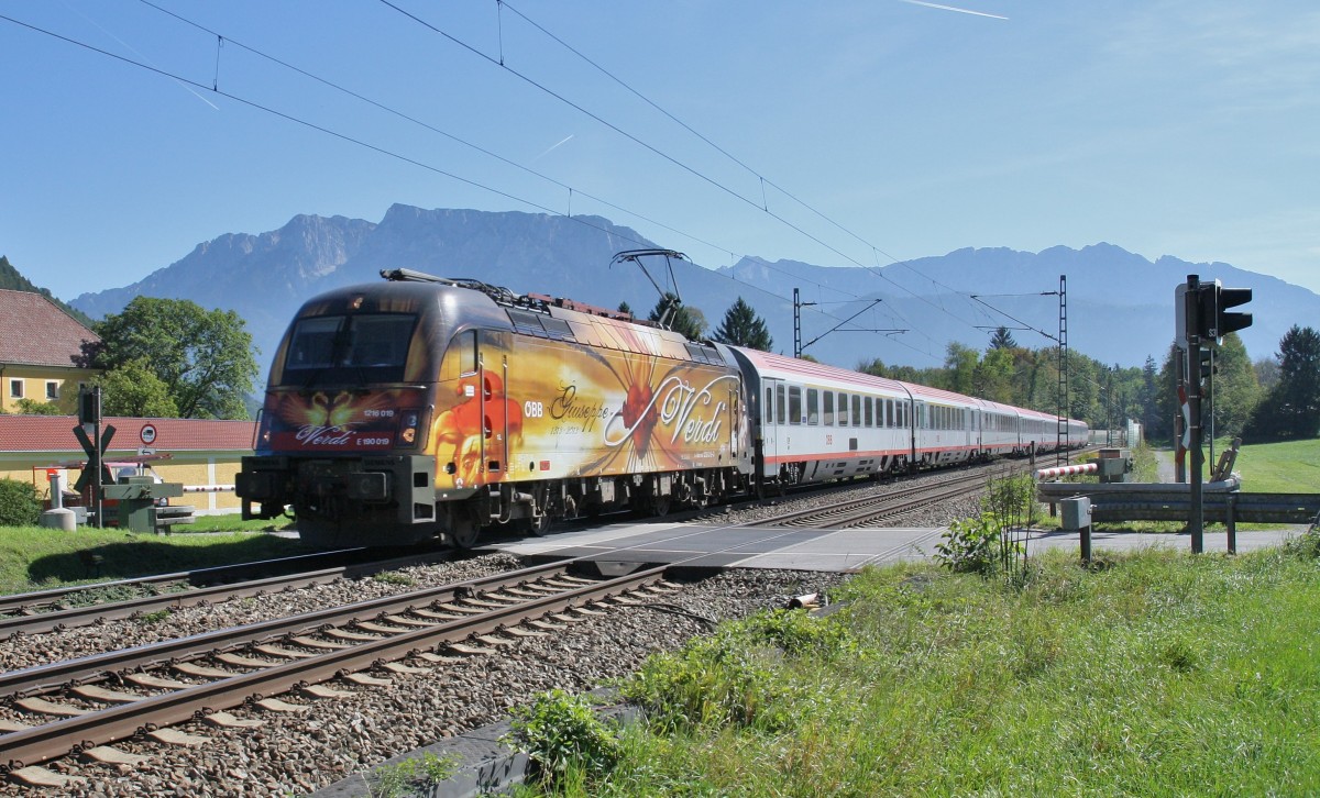 1216 019-0 ``Verdi`` ist am 24.9.2013 mit einem EC von Italien nach München unterwegs, hier am Bahnübergang Niederaudorf. Im Hintergrund die Gebirgskette des wilden Kaisers.
