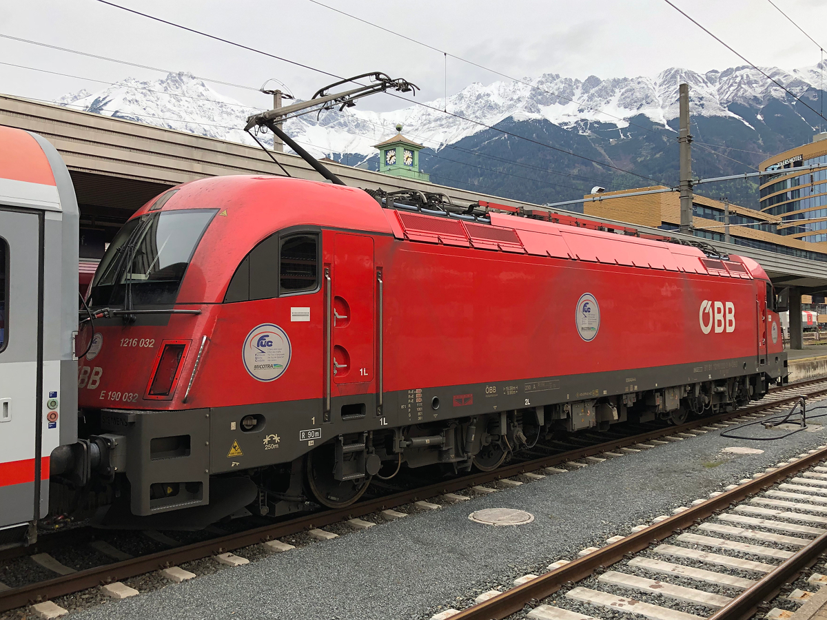 1216 032 mit  FUC - der Zug der Sprachen  Stickern wartet mit dem EC 288 auf die Ausfahrt  nach München Hbf. Innsruck Hbf am 21.05.2021