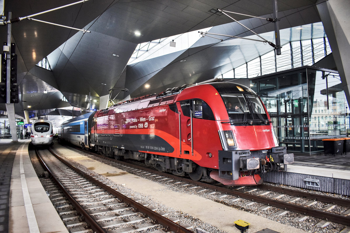 1216 229-5  Spirit of Praha , hält mit dem railjet 75  Franz Schubert  (Praha hl.n. - Wien Hbf - Graz Hbf), in Wien Hbf.

Links daneben zu sehen, ist 411 073-0 als ICE 90 (Wien Hbf - Passau Hbf - Kassel-Wilhelmshöhe - Hamburg Altona)

Aufgenommen am 23.11.2018.