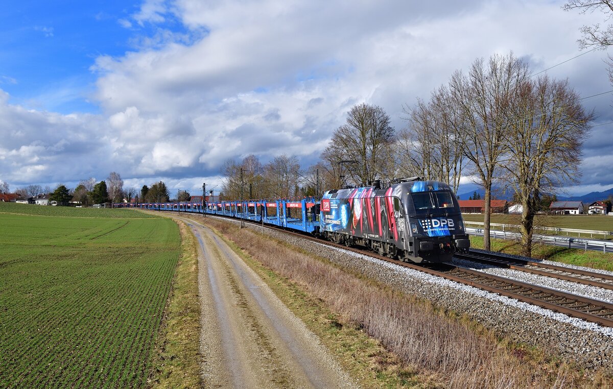 1216 940 mit einem leeren Autozug am 10.03.2023 bei Langenisarhofen.