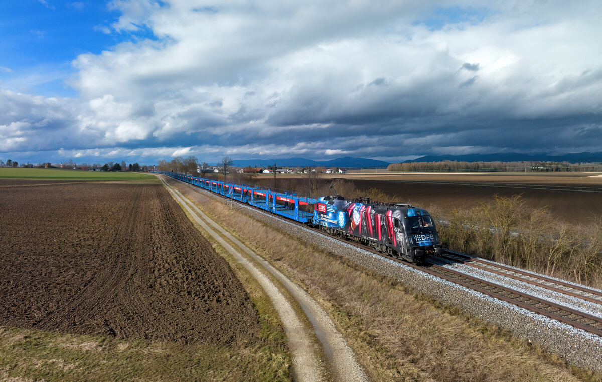 1216 940 mit einem leeren Autozug am 10.03.2023 bei Langenisarhofen.
