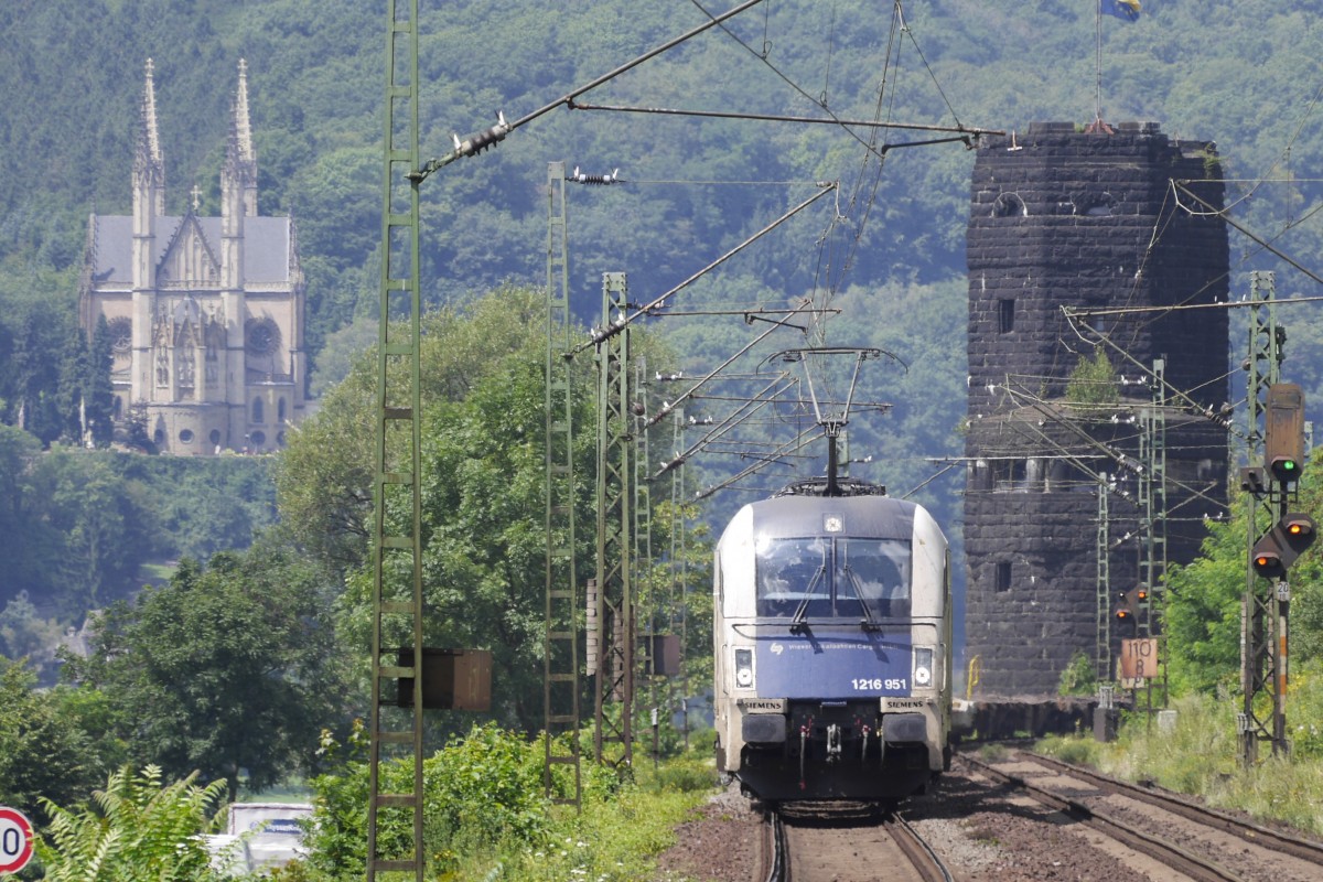 1216 951 der Wiener Lokalbahnen auf der rechten Rheinstrecke, eingerahmt von Remagens beiden Sehenswürdigkeiten, der Apollinaris-Kirche auf dem linken Rheinufer und dem rechtsrheinischen Brückenkopf der ehemaligen Eisenbahnbrücke (Erpel/Rhein, 24.7.14).