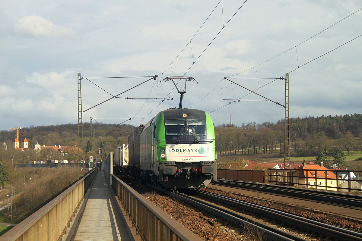 1216 954 von Hödlmayr International zieht am 31.03.2015 einen Güterzug über die Donaubrücke bei Regensburg-Prüfening. 