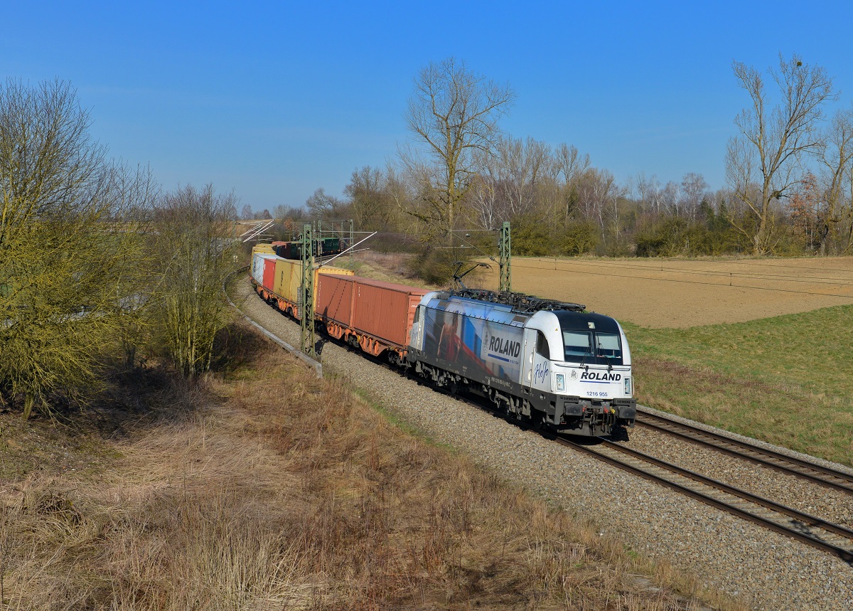 1216 955 mit einem Containerzug am 18.03.2015 bei Langenisarhofen. 