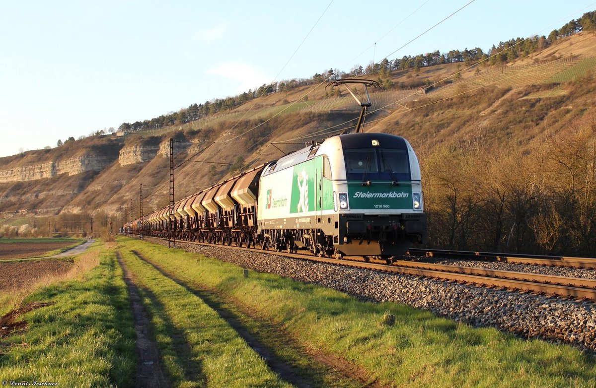 1216 960 der Steiermarkbahn durchfuhr mit ihren geschlossenen Schüttgutwagen, im schönen Abendlicht, den Ort Thüngersheim am 06.04.2018
